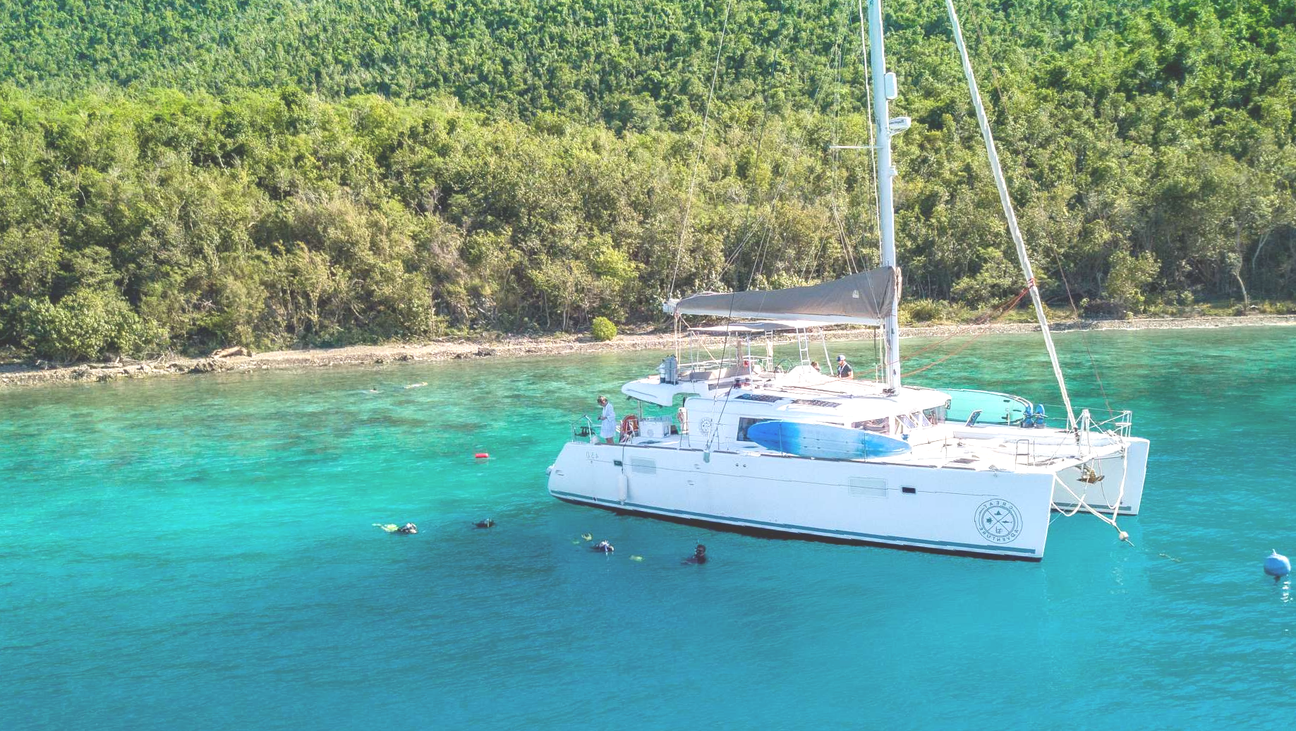 Great Adventure in clear turquoise water beside a green coastline