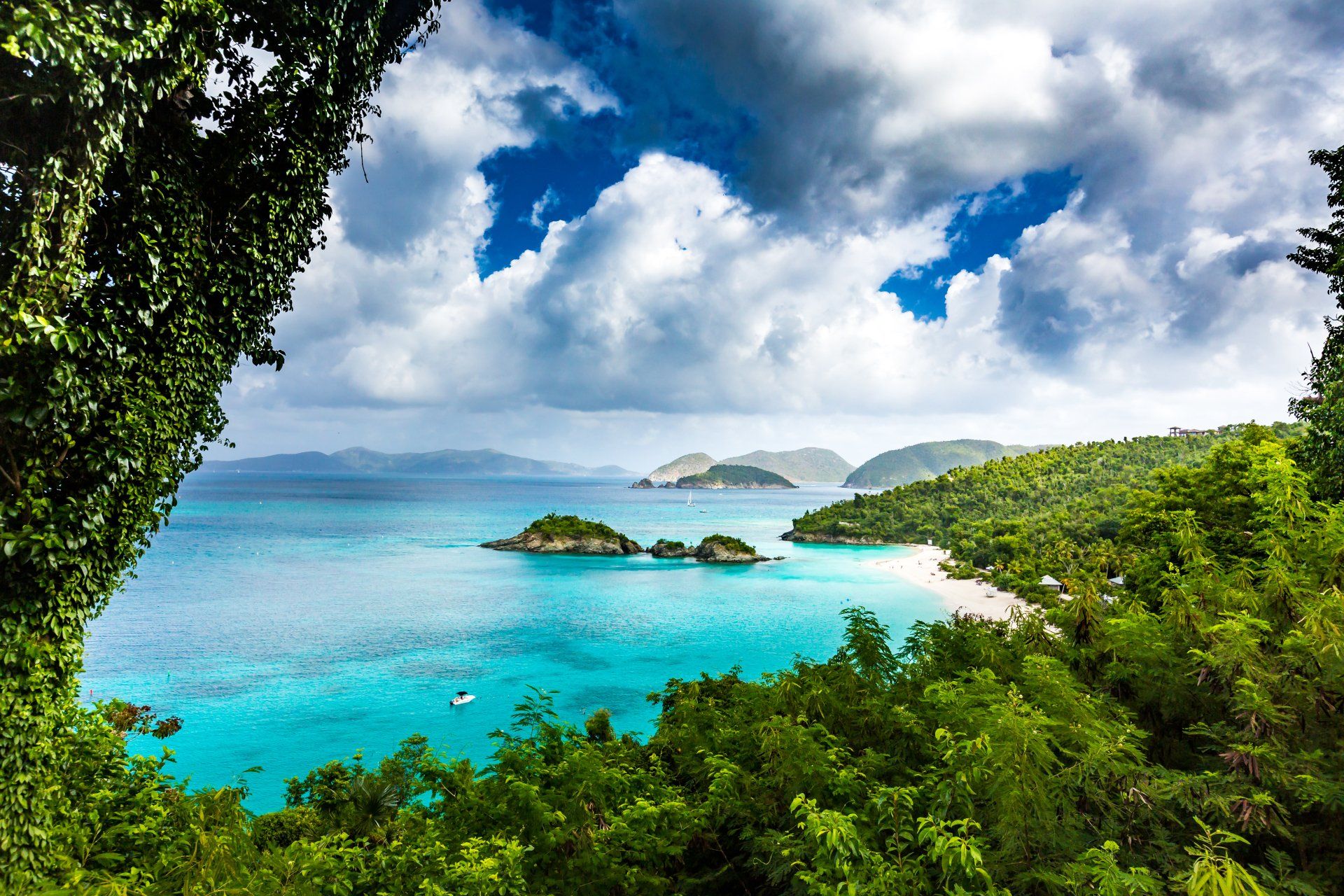 Turquoise island bay framed by green hills and tropical trees